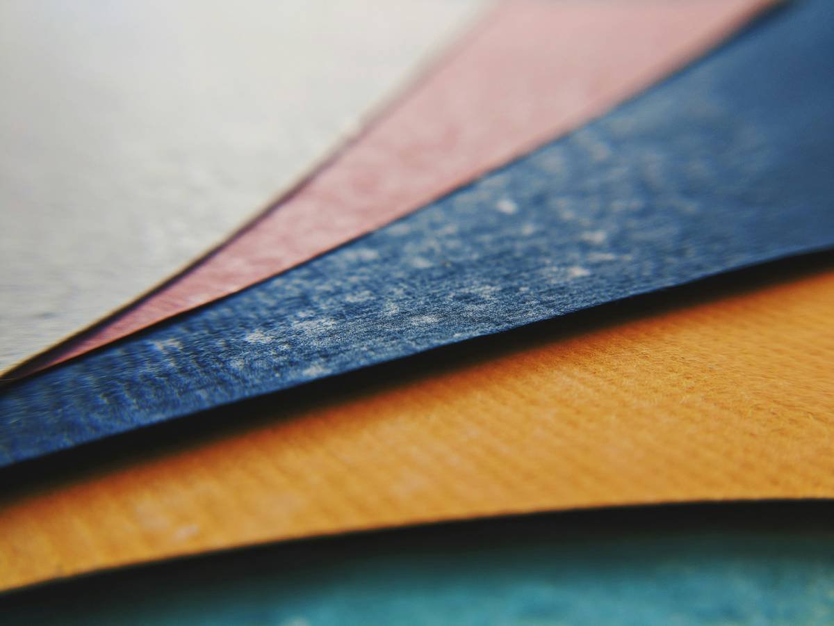 Chart showing types of flooring adhesives: asphalt-based mastic (black, sticky), acrylic (milky white, dries clear), pressure-sensitive (rubbery film), and epoxy (hard, glossy). Includes removal difficulty ratings.