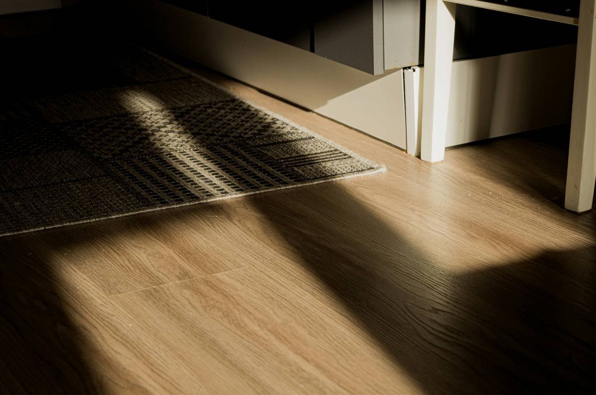 Before and after photos of basement flooring: left shows bubbling adhesive planks, right shows smooth, seamless installation after proper prep